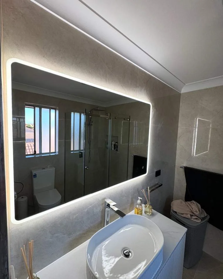 Modern bathroom with illuminated LED mirror and strip lighting