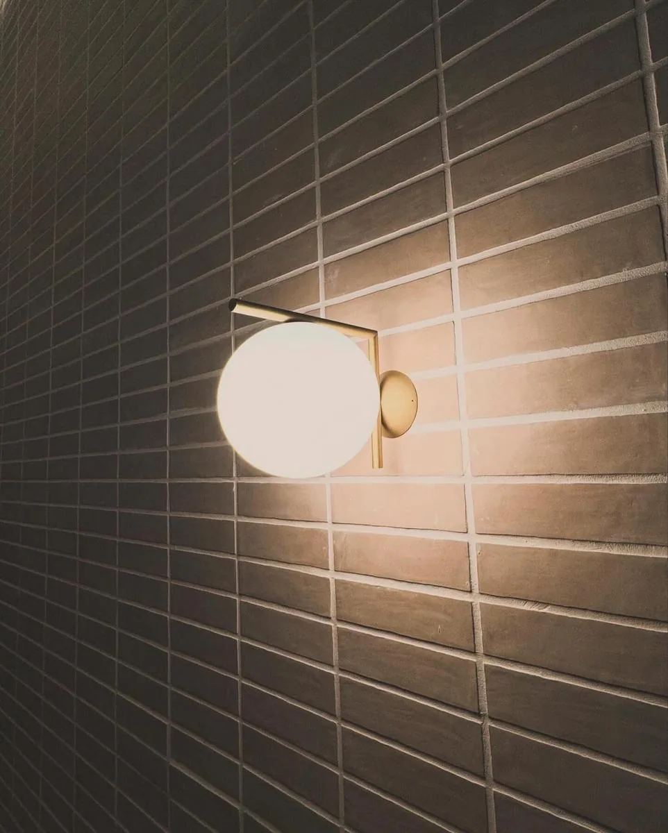 Decorative wall-mounted light against tiled wall