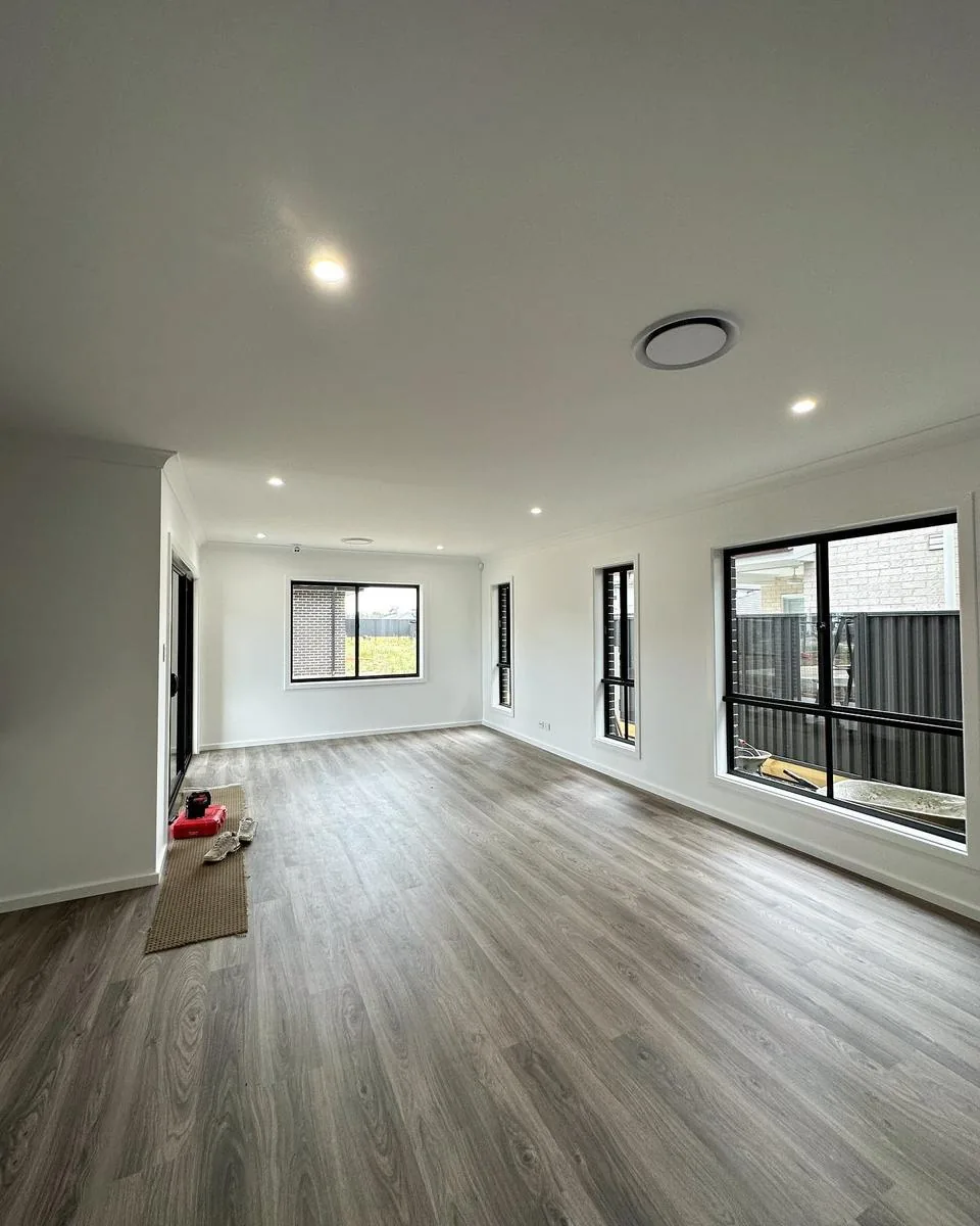 Open plan living room with recessed downlights and ceiling ventilation
